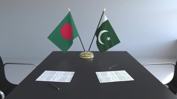 Flaggen aus Bangladesch und Pakistan und Papiere auf dem Tisch. Verhandlungen und die Unterzeichnung eines internationalen Abkommens. konzeptionelle 3D-Animation — Stockvideo