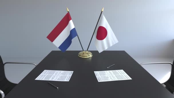 Bandiere dei Paesi Bassi e del Giappone e documenti sul tavolo. Negoziati e firma di un accordo internazionale. Animazione 3D concettuale — Video Stock