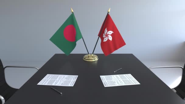 Banderas de Bangladesh y Hong Kong y papeles sobre la mesa. Negociaciones y firma de un acuerdo internacional. Animación 3D conceptual — Vídeos de Stock