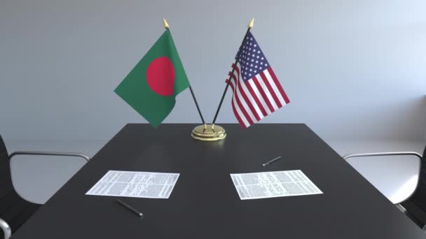 Lijst van vlaggen van Bangladesh en de Verenigde Staten en de papieren op tafel. Onderhandelingen en ondertekening van een internationale overeenkomst. Conceptuele 3d animatie — Stockvideo