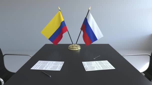 Прапори Колумбії та Росії і документи на столі. Переговорів і підписання міжнародного договору. Концептуальні 3d анімація — стокове відео