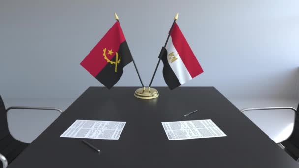 Flaggen von Angola und Ägypten und Papiere auf dem Tisch. Verhandlungen und die Unterzeichnung eines internationalen Abkommens. konzeptionelle 3D-Animation — Stockvideo