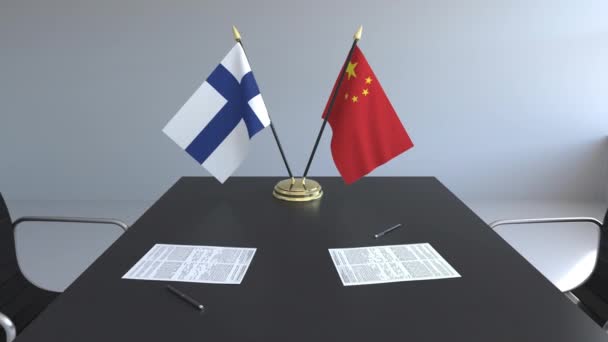 Flaggen von Finnland und China und Papiere auf dem Tisch. Verhandlungen und die Unterzeichnung eines internationalen Abkommens. konzeptionelle 3D-Animation — Stockvideo