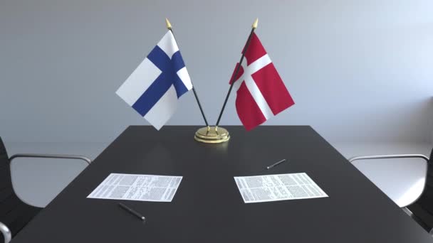 Flaggen Finnlands und Dänemarks und Papiere auf dem Tisch. Verhandlungen und die Unterzeichnung eines internationalen Abkommens. konzeptionelle 3D-Animation — Stockvideo