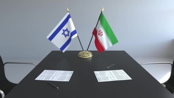 Флаги Израиля и Ирана и бумаги на столе. Переговоры и подписание международного соглашения. Концептуальная 3D анимация — стоковое видео
