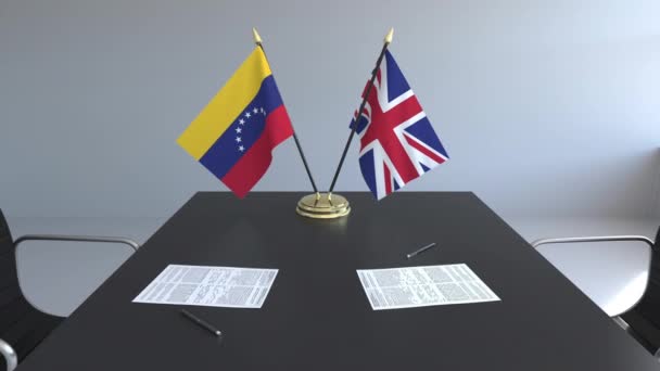 Flaggen der venezuela und des vereinigten Königreichs und Papiere auf dem Tisch. Verhandlungen und die Unterzeichnung eines internationalen Abkommens. konzeptionelle 3D-Animation — Stockvideo