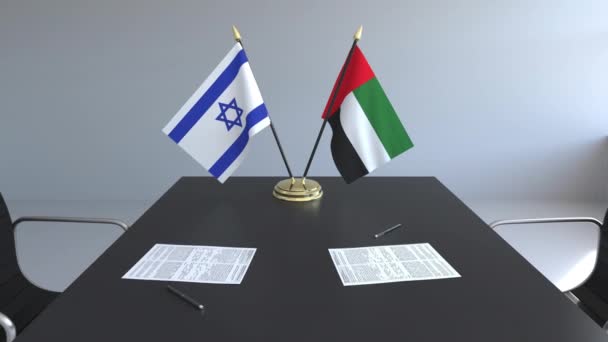 Bandeiras de Israel e dos Emirados Árabes Unidos e papéis na mesa. Negociações e assinatura de um acordo internacional. Animação 3D conceitual — Vídeo de Stock