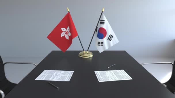 Flaggen von Hongkong und Südkorea und Papiere auf dem Tisch. Verhandlungen und die Unterzeichnung eines internationalen Abkommens. konzeptionelle 3D-Animation — Stockvideo