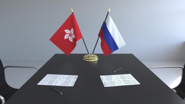 Flaggen von Hongkong und Russland und Papiere auf dem Tisch. Verhandlungen und die Unterzeichnung eines internationalen Abkommens. konzeptionelle 3D-Animation — Stockvideo