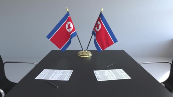 Flaggen Nordkoreas und Papiere auf dem Tisch. Verhandlungen und Unterzeichnung eines Abkommens. konzeptionelle 3D-Animation — Stockvideo