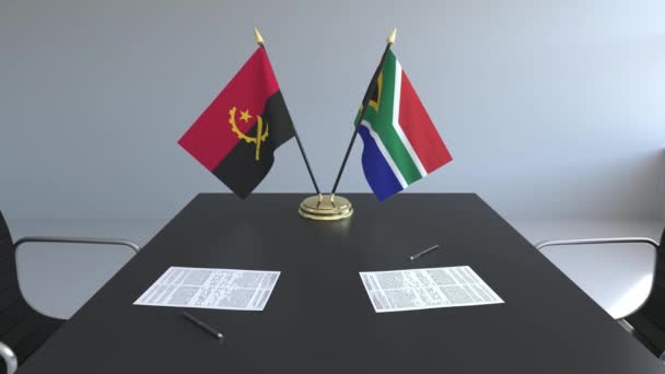 Bendera Angola dan Afrika Selatan dan kertas di atas meja. Negosiasi dan penandatanganan perjanjian internasional. Animasi 3D konseptual — Stok Video