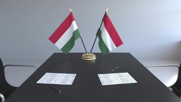 Σημαίες της Ουγγαρίας και χαρτιά στο τραπέζι. Οι διαπραγματεύσεις και η υπογραφή μιας συμφωνίας. Εννοιολογική 3d animation — Αρχείο Βίντεο