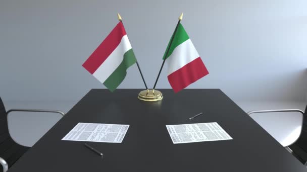 Flags of Hungary and Italy and papers on the table. Negotiations and signing an international agreement. Conceptual 3D animation — Stock Video