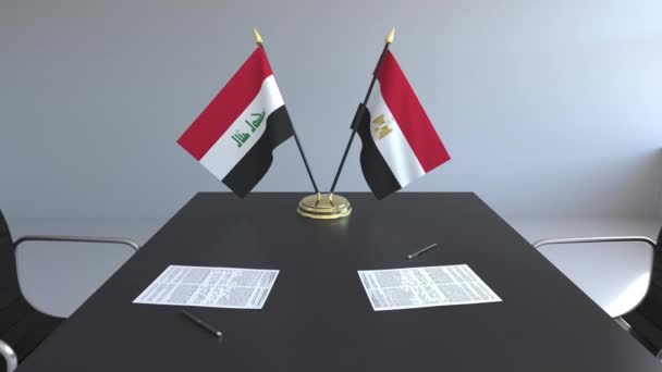 Флаги Ирака и Египта и бумаги на столе. Переговоры и подписание международного соглашения. Концептуальная 3D анимация — стоковое видео