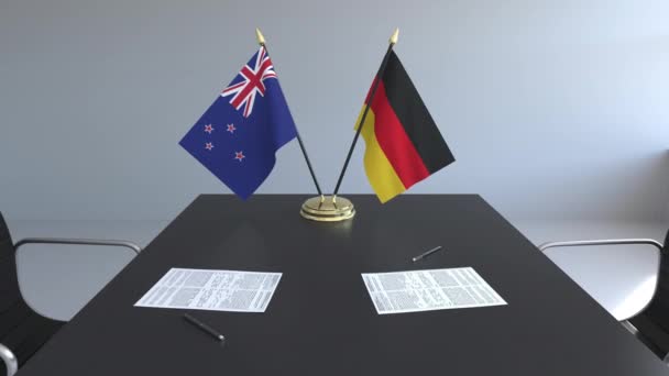 Drapeaux de Nouvelle-Zélande et d'Allemagne et papiers sur la table. Négociations et signature d'un accord international. Animation 3D conceptuelle — Video