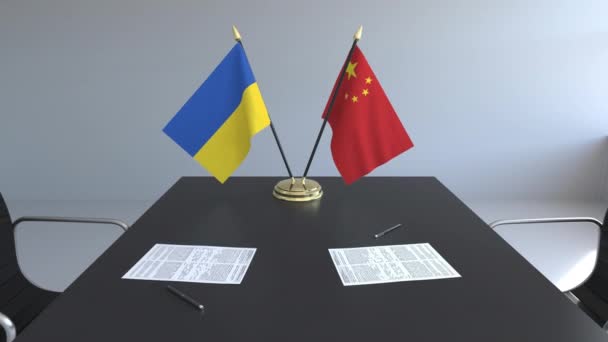 Flaggen der Ukraine und Chinas und Papiere auf dem Tisch. Verhandlungen und die Unterzeichnung eines internationalen Abkommens. konzeptionelle 3D-Animation — Stockvideo