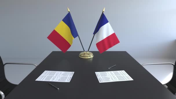 Flaggen Rumäniens und Frankreichs und Papiere auf dem Tisch. Verhandlungen und die Unterzeichnung eines internationalen Abkommens. konzeptionelle 3D-Animation — Stockvideo