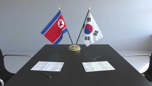 Flaggen Nord- und Südkoreas und Papiere auf dem Tisch. Verhandlungen und die Unterzeichnung eines internationalen Abkommens. konzeptionelle 3D-Animation — Stockvideo