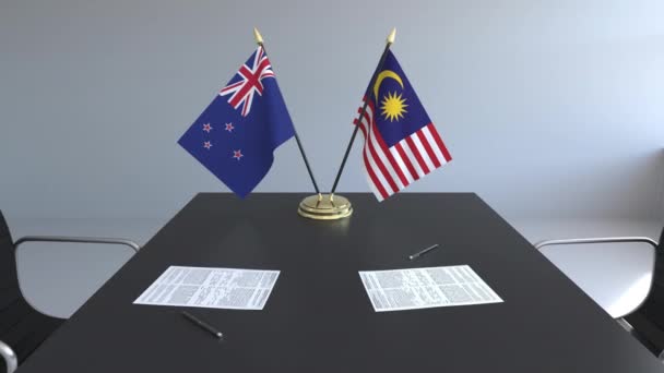 Flaggen von Neuseeland und Malaysia und Papiere auf dem Tisch. Verhandlungen und die Unterzeichnung eines internationalen Abkommens. konzeptionelle 3D-Animation — Stockvideo