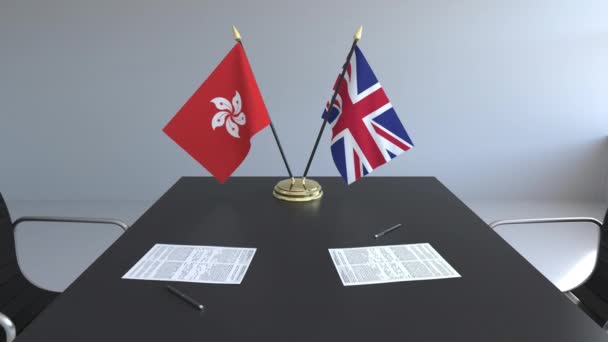 Прапори Гонконг і Великої Британії і документи на столі. Переговорів і підписання міжнародного договору. Концептуальні 3d анімація — стокове відео