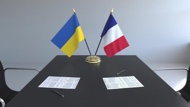 Флаги Украины и Франции и бумаги на столе. Переговоры и подписание международного соглашения. Концептуальная 3D анимация — стоковое видео