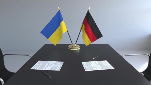 Lijst van vlaggen van Oekraïne en Duitsland en papieren op de tafel. Onderhandelingen en ondertekening van een internationale overeenkomst. Conceptuele 3d animatie — Stockvideo