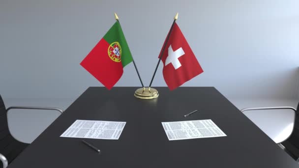 Flaggen Portugals und der Schweiz und Papiere auf dem Tisch. Verhandlungen und die Unterzeichnung eines internationalen Abkommens. konzeptionelle 3D-Animation — Stockvideo