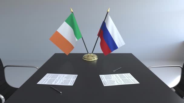 Flags of Ireland and Russia and papers on the table. Negotiations and signing an international agreement. Conceptual 3D animation — Stock Video