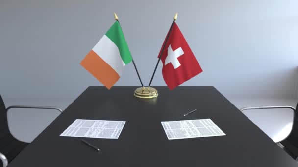 Flaggen Irlands und der Schweiz und Papiere auf dem Tisch. Verhandlungen und die Unterzeichnung eines internationalen Abkommens. konzeptionelle 3D-Animation — Stockvideo