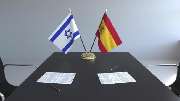 Флаги Израиля и Испании и бумаги на столе. Переговоры и подписание международного соглашения. Концептуальная 3D анимация — стоковое видео