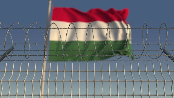 Bandeira de acenar desfocada da Hungria atrás da cerca de arame farpado. Renderização 3D — Fotografia de Stock