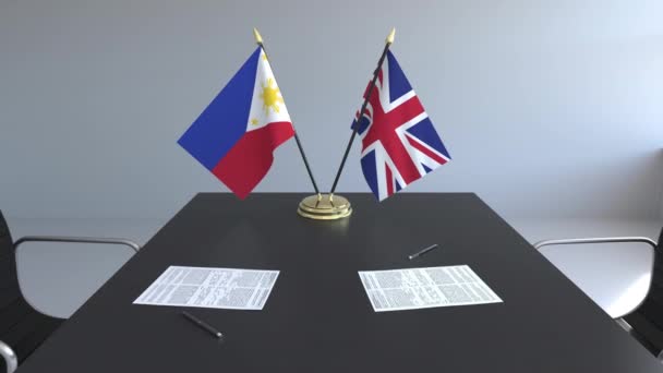 Σημαίες των Φιλιππίνων και το Ηνωμένο Βασίλειο και τα χαρτιά στο τραπέζι. Οι διαπραγματεύσεις και η υπογραφή μιας διεθνούς συμφωνίας. Εννοιολογική 3d animation — Αρχείο Βίντεο