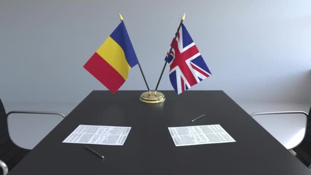 Flaggen Rumäniens und des vereinigten Königreichs und Papiere auf dem Tisch. Verhandlungen und die Unterzeichnung eines internationalen Abkommens. konzeptionelle 3D-Animation — Stockvideo