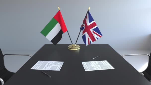 Banderas de los Emiratos Árabes Unidos y el Reino Unido y documentos sobre la mesa. Negociaciones y firma de un acuerdo internacional. Animación 3D conceptual — Vídeos de Stock