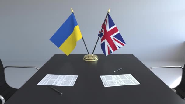 Flaggen der Ukraine und des vereinigten Königreichs und Papiere auf dem Tisch. Verhandlungen und die Unterzeichnung eines internationalen Abkommens. konzeptionelle 3D-Animation — Stockvideo