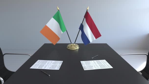 Flaggen Irlands und der Niederlande und Papiere auf dem Tisch. Verhandlungen und die Unterzeichnung eines internationalen Abkommens. konzeptionelle 3D-Animation — Stockvideo