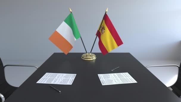 Флаги Ирландии и Испании и бумаги на столе. Переговоры и подписание международного соглашения. Концептуальная 3D анимация — стоковое видео