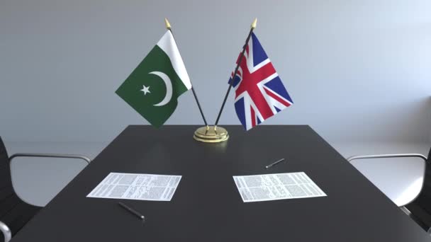 Flaggen Pakistans und des vereinigten Königreichs und Papiere auf dem Tisch. Verhandlungen und die Unterzeichnung eines internationalen Abkommens. konzeptionelle 3D-Animation — Stockvideo