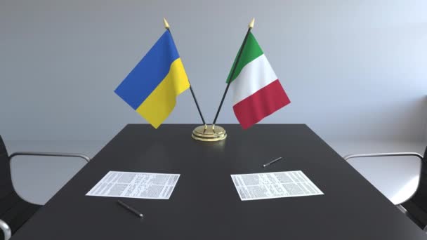 Флаги Украины и Италии и бумаги на столе. Переговоры и подписание международного соглашения. Концептуальная 3D анимация — стоковое видео