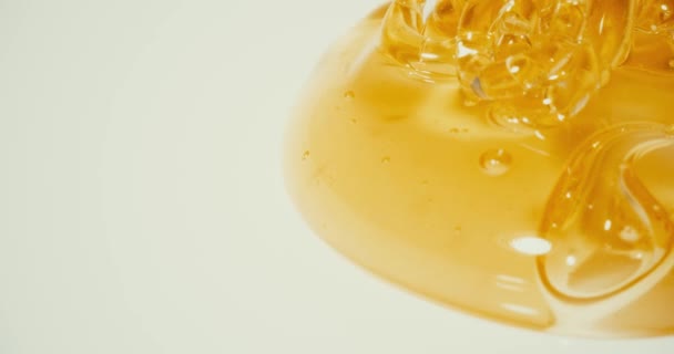 Wylewanie złoty miód na talerzu, zbliżenie — Wideo stockowe