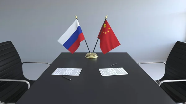 Flags of Russia and China and papers on the table. Negotiations and signing an international agreement. Conceptual 3D rendering