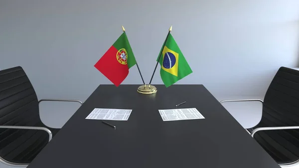Drapelele Portugaliei şi Braziliei şi hârtiile de pe masă. Negocieri și semnarea unui acord internațional. Redare 3D conceptuală — Fotografie, imagine de stoc
