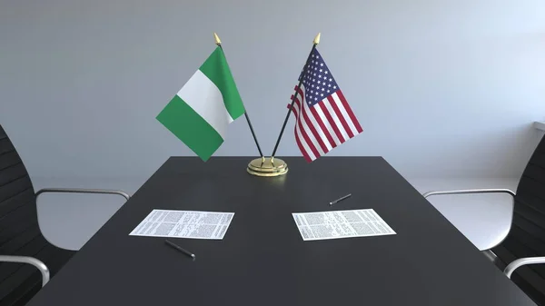 ナイジェリアとアメリカ合衆国とテーブルの上の論文のフラグです。交渉と国際協定に署名します。概念 3 d レンダリング — ストック写真