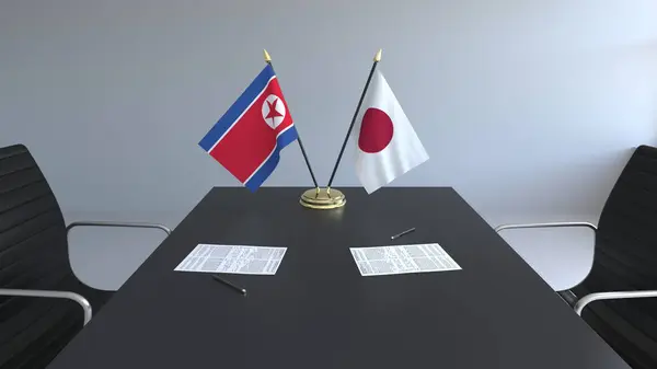 Bandeiras da Coreia do Norte e Japão e papéis na mesa. Negociações e assinatura de um acordo internacional. Renderização 3D conceitual — Fotografia de Stock