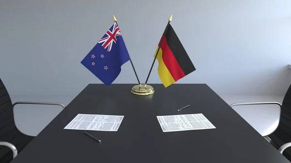 Flaggen von Neuseeland und Deutschland und Papiere auf dem Tisch. Verhandlungen und die Unterzeichnung eines internationalen Abkommens. konzeptionelles 3D-Rendering — Stockfoto
