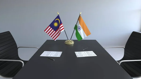 Flaggen von Malaysia und Indien und Papiere auf dem Tisch. Verhandlungen und die Unterzeichnung eines internationalen Abkommens. konzeptionelles 3D-Rendering — Stockfoto