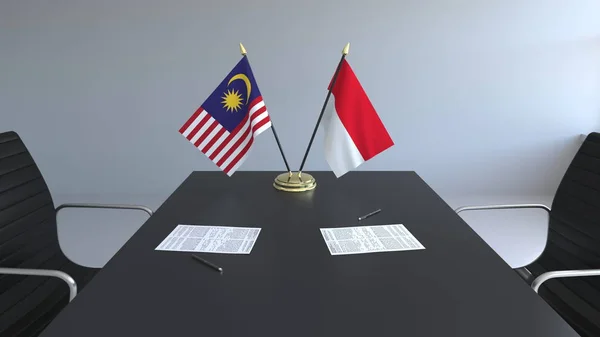 Flaggor i Malaysia och Indonesien och papper på bordet. Förhandlingarna och underteckna internationella avtal. Konceptuell 3d-rendering — Stockfoto