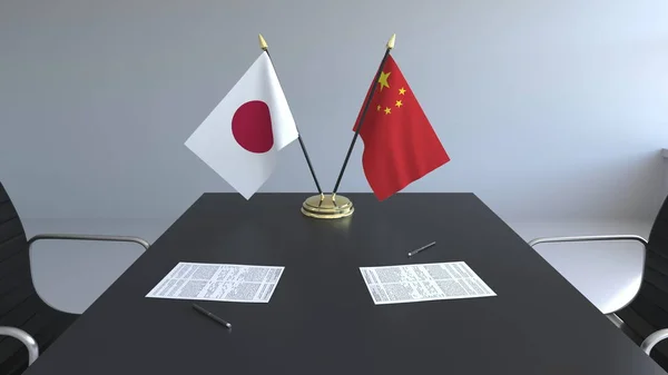 Bandeiras do Japão e da China e papéis na mesa. Negociações e assinatura de um acordo internacional. Renderização 3D conceitual — Fotografia de Stock