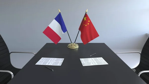 Fahnen von Frankreich und China und Papiere auf dem Tisch. Verhandlungen und die Unterzeichnung eines internationalen Abkommens. konzeptionelles 3D-Rendering — Stockfoto