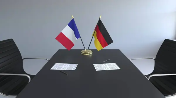 Fransa ve Almanya ve kağıtları masaya bayrakları. Müzakereler ve uluslararası bir anlaşma imzalama. Kavramsal 3d render — Stok fotoğraf
